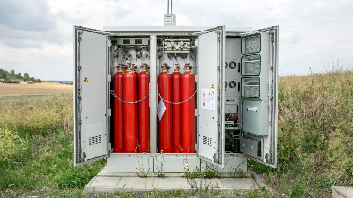 Open portrayal of an off-grid power supply system with hydrogen showing gas bottles and technology