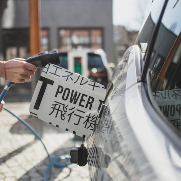 Woman charging battery electric car