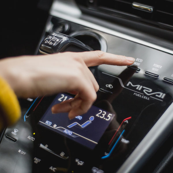 Hand pointing at button inside a fuell cell car