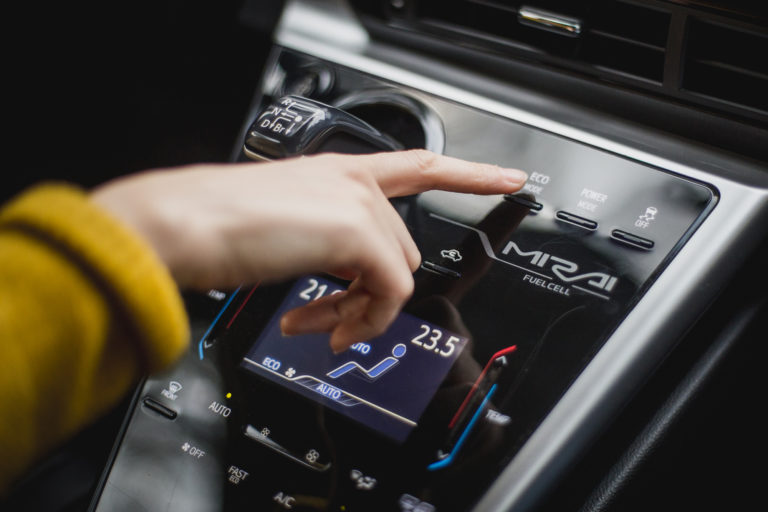 Hand pointing at button inside a fuell cell car